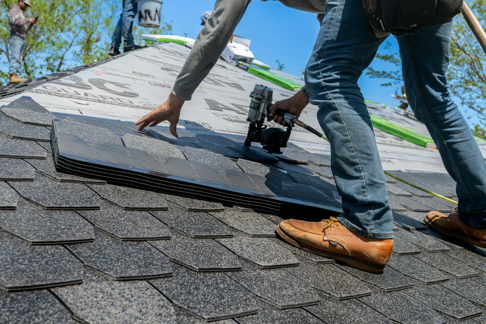 Professional roofer installing shingles on a new roof